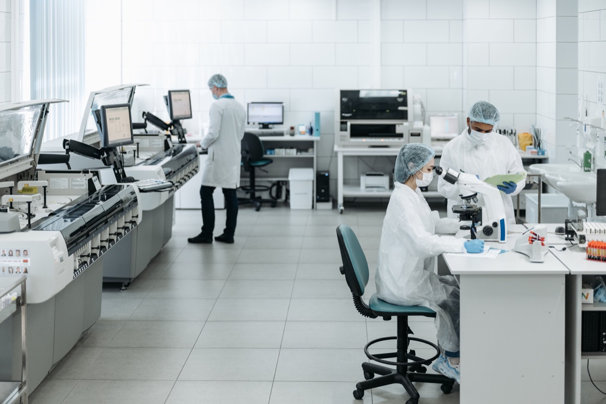 Laboratuvarda mikroskop ve analiz cihazlarıyla çalışan sağlık personeli